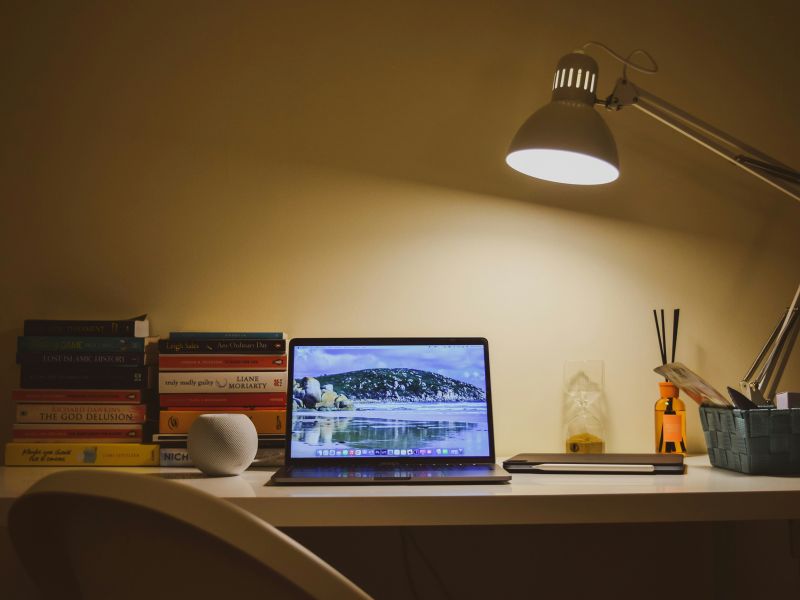 home working desk table with laptop, lamp, books and stuff